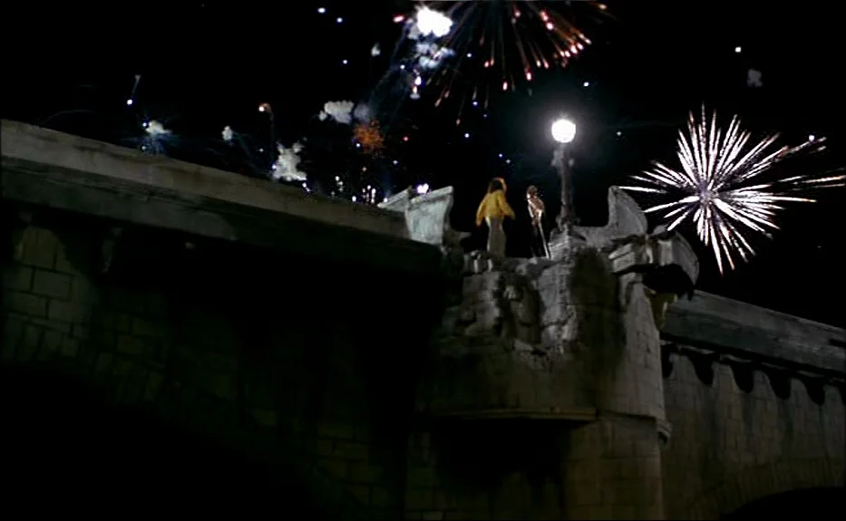 Les Amants Du Pont Neuf (The Lovers on the Bridge) (1991) movie still: wide — An stone masonry bridge arches over a dark void during a nighttime…
