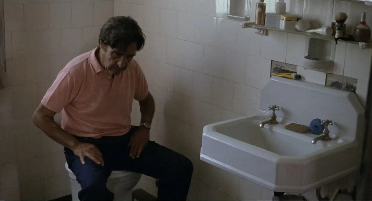 La Ciénaga (2001) movie still: medium — A small residential bathroom features white square wall tiles and a porcelain sink. An older man wearing a…