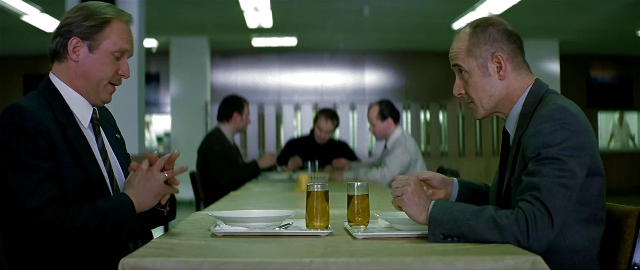 The Lives of Others (2006) movie still: medium — A spacious, minimalist institutional dining hall features long tables under clinical fluorescent…