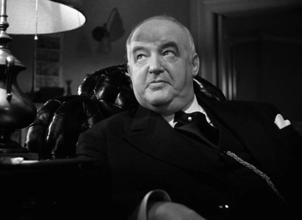 The Maltese Falcon (1941) movie still: medium — A dark study with a leather armchair and a table lamp on the side. An older man in a formal suit…