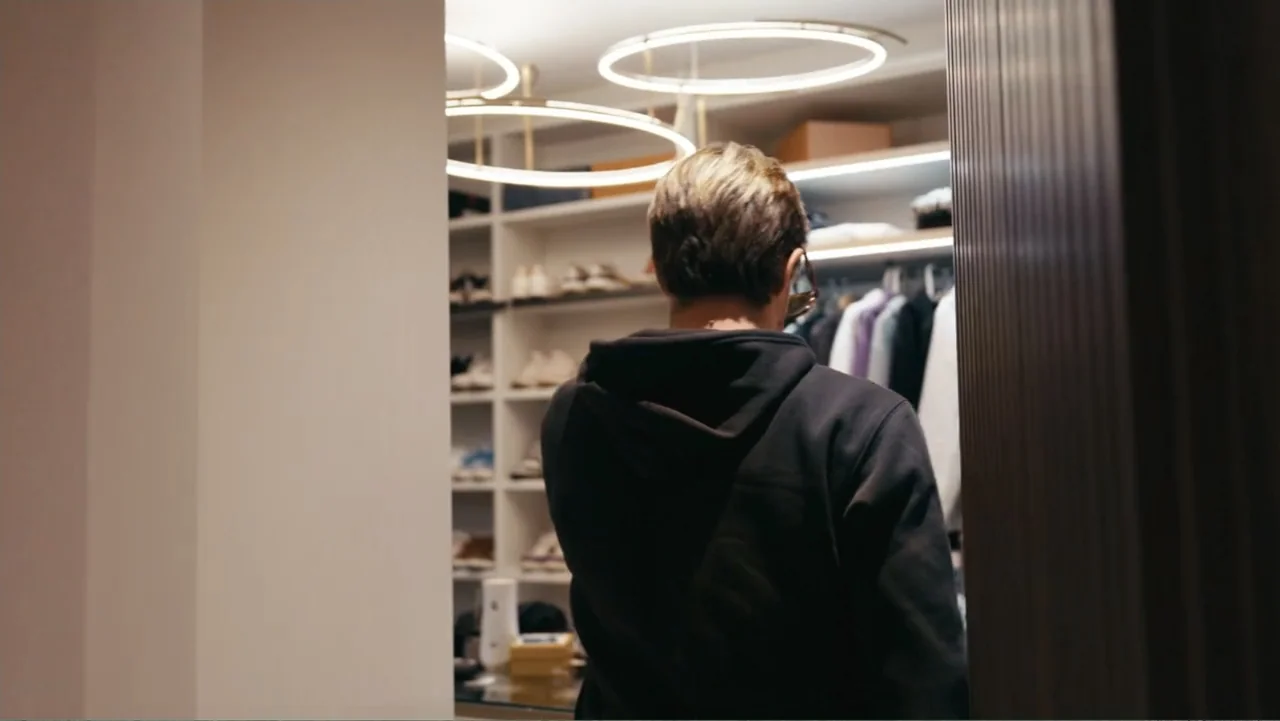FRAGILE - The story of Nicolò Fagioli (2024) movie still: medium — A contemporary walk-in closet features white shelving units filled with shoes and…