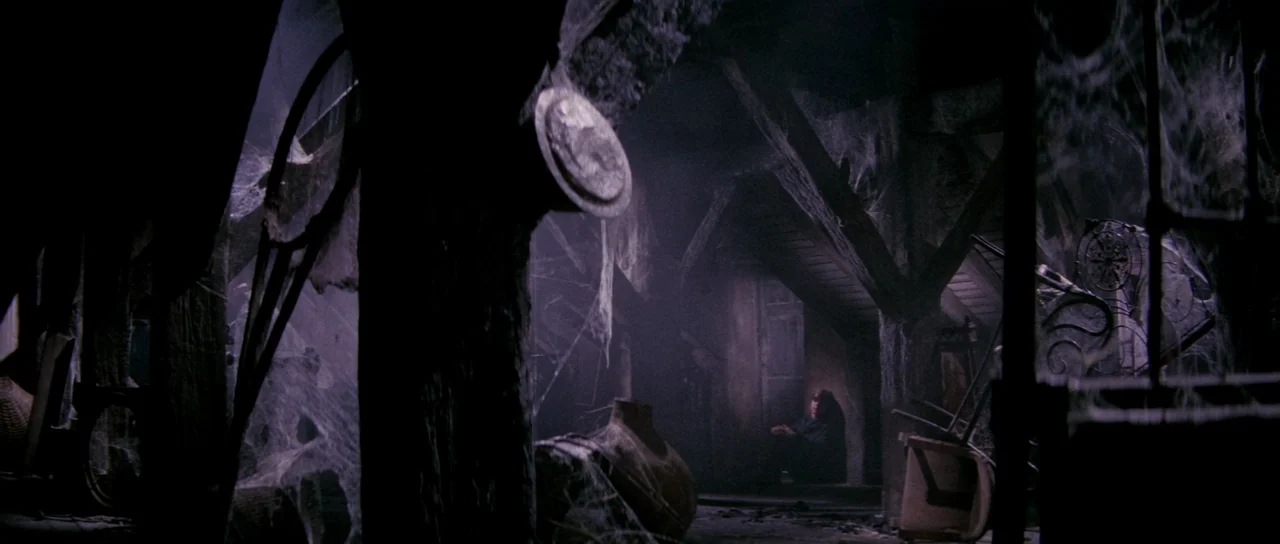 The House That Screamed (1969) movie still: wide — A dark, cluttered attic is filled with thick cobwebs and heavy wooden beams. A solitary figure…