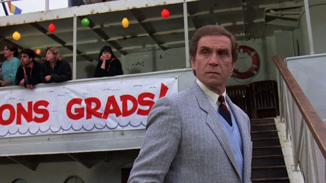 Friday the 13th Part VIII: Jason Takes Manhattan (1989) movie still: medium — An older man in a blazer stands on the deck of a boat. Behind him, a…