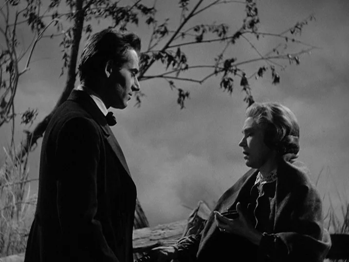 Young Mr. Lincoln (1939) movie still: medium — An outdoor landscape features two people conversing near a sparse, leafless tree. A man in a dark…