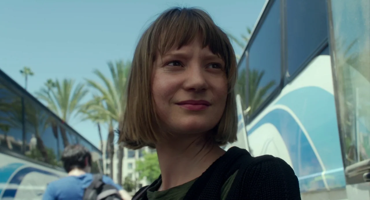 Maps to the Stars (2014) movie still: medium — An outdoor transit area featuring parked passenger buses and distant palm trees under clear sky. A…