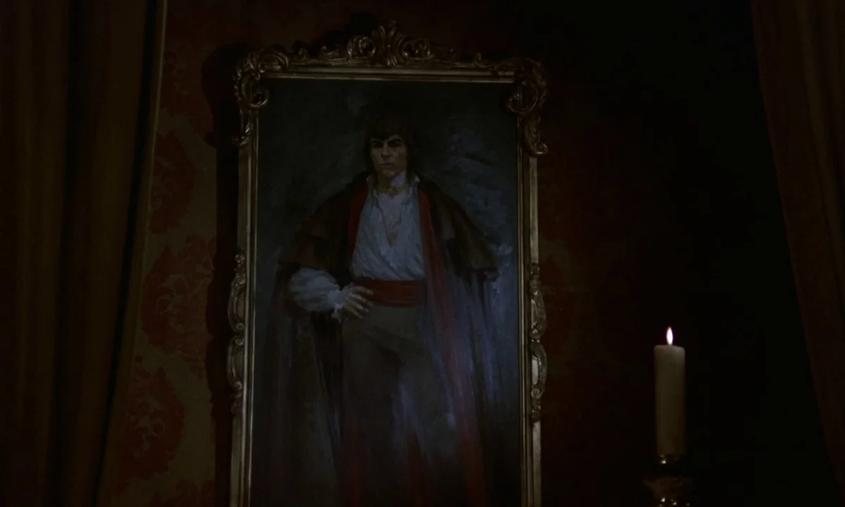 Vampire Circus (1972) movie still: medium — A framed portrait hangs on a dark red wallpapered wall. A lit white candle sits on a stand to the right…