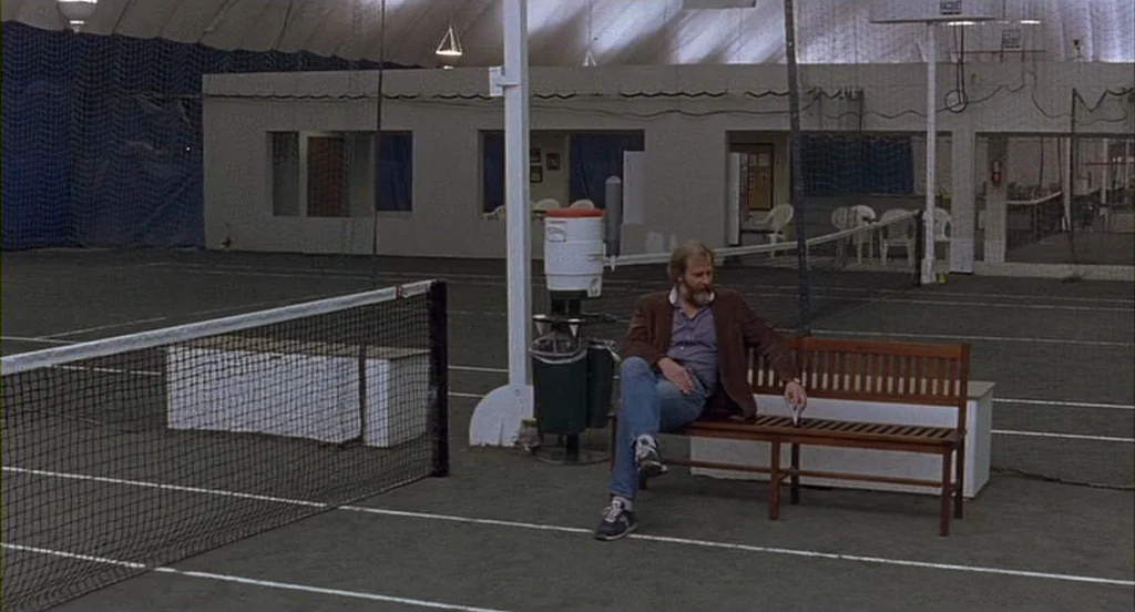 The Squid and the Whale (2005) movie still: wide — An indoor tennis facility with green court surfaces, white boundary lines, and high ceilings. A…