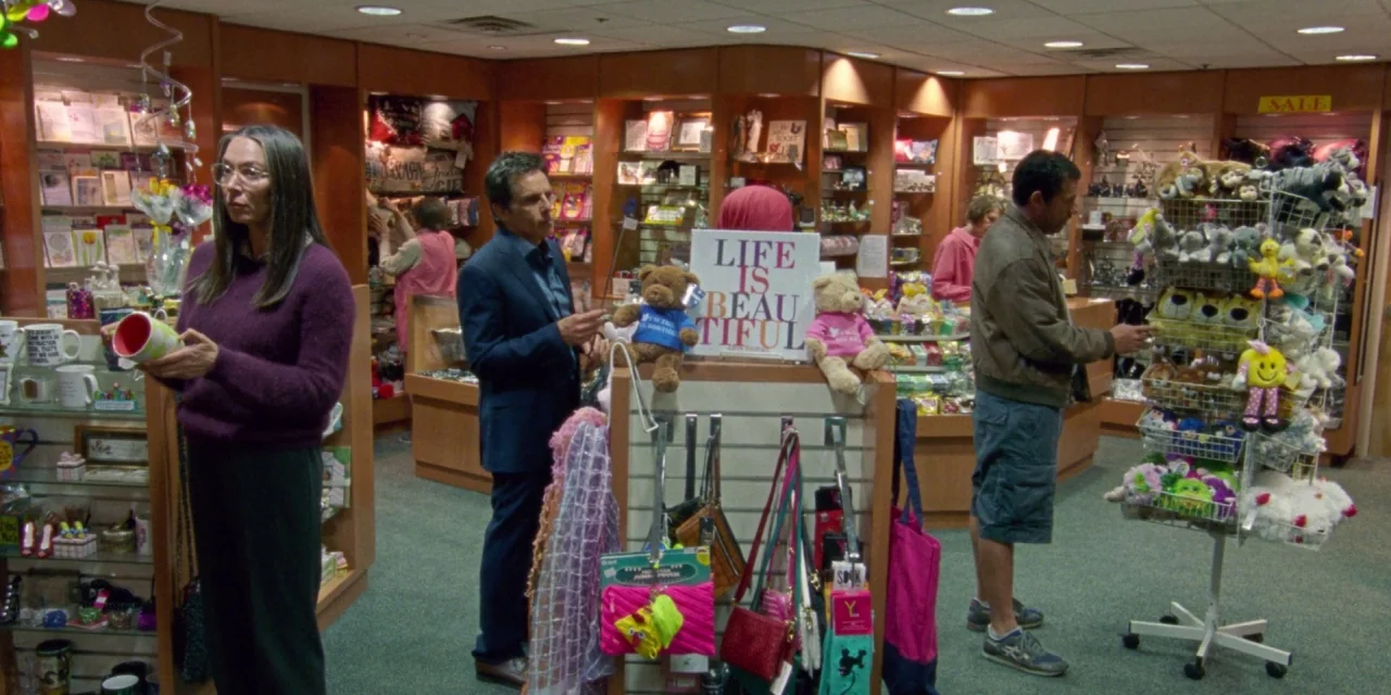 The Meyerowitz Stories (New and Selected) (2017) movie still: wide — A well-lit gift shop features wooden shelves filled with various greeting cards…