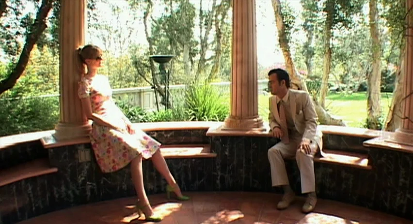 Inland Empire (2006) movie still: wide — A stone gazebo with neoclassical columns features marble base accents and circular floor tile. A man and…