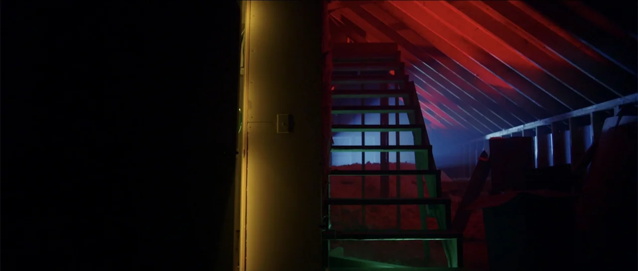 Halloween III: Season of the Witch (1982) movie still: wide — An unfinished attic features exposed wooden rafters and floor joists. A wooden ladder…