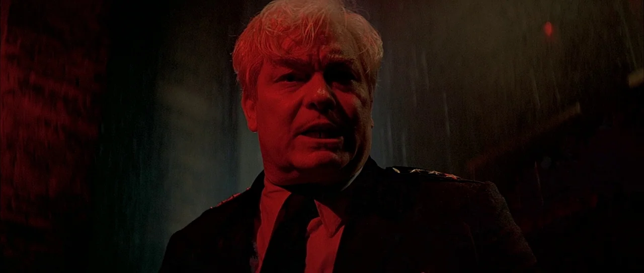 The Untouchables (1987) movie still: closeup — An older man stands on a dark city street during a night rainstorm. He faces the camera directly…