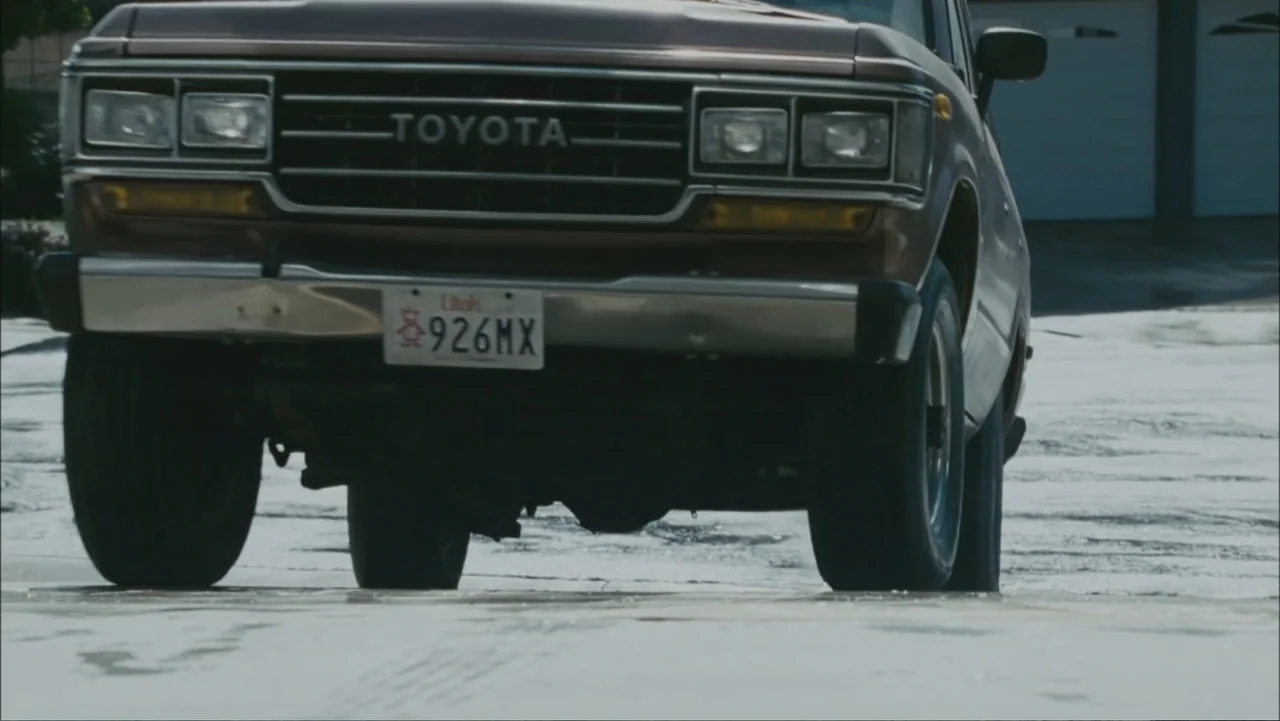 The Stepfather (2009) movie still: medium — A brown Toyota Land Cruiser sits parked on a flat residential driveway. The front of the vehicle faces…