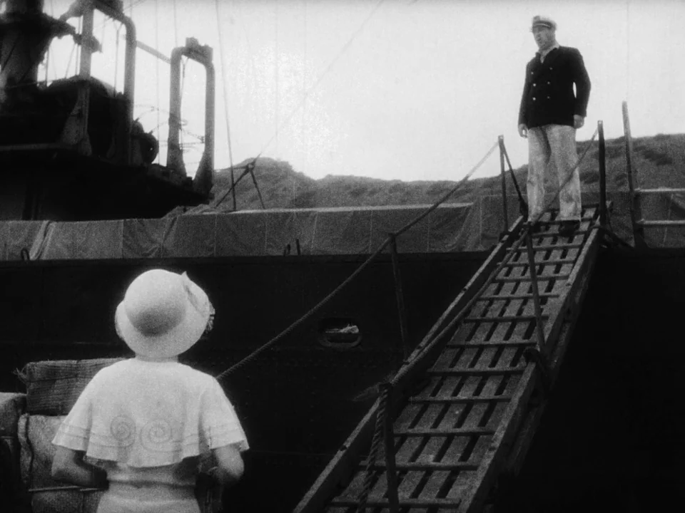 Island of Lost Souls (1932) movie still: wide — A wooden gangplank connects a large dark metal ship to a dock area. A man in a captain's uniform…