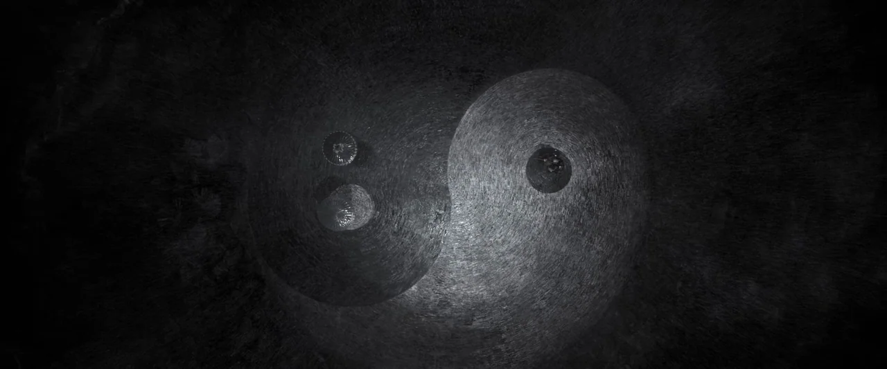 Shadow (2018) movie still: establishing — A stone paved courtyard is arranged in the shape of a large yin-yang symbol. Two circular structures are…