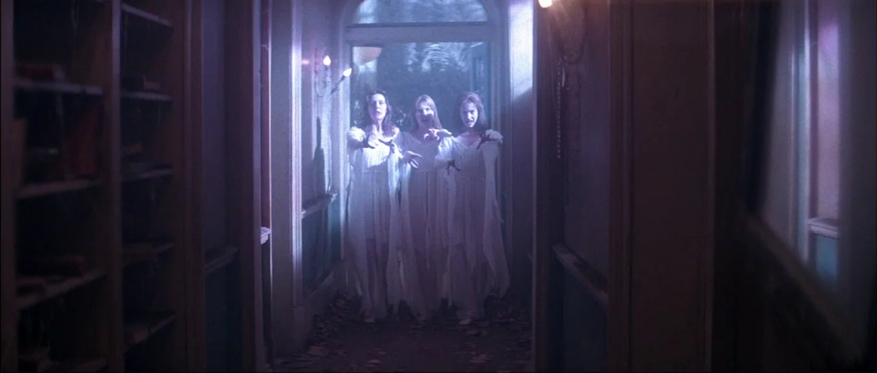 The Monster Squad (1987) movie still: fullbody — An interior residential hallway features wooden wall paneling and a doorway leading outside. Three…