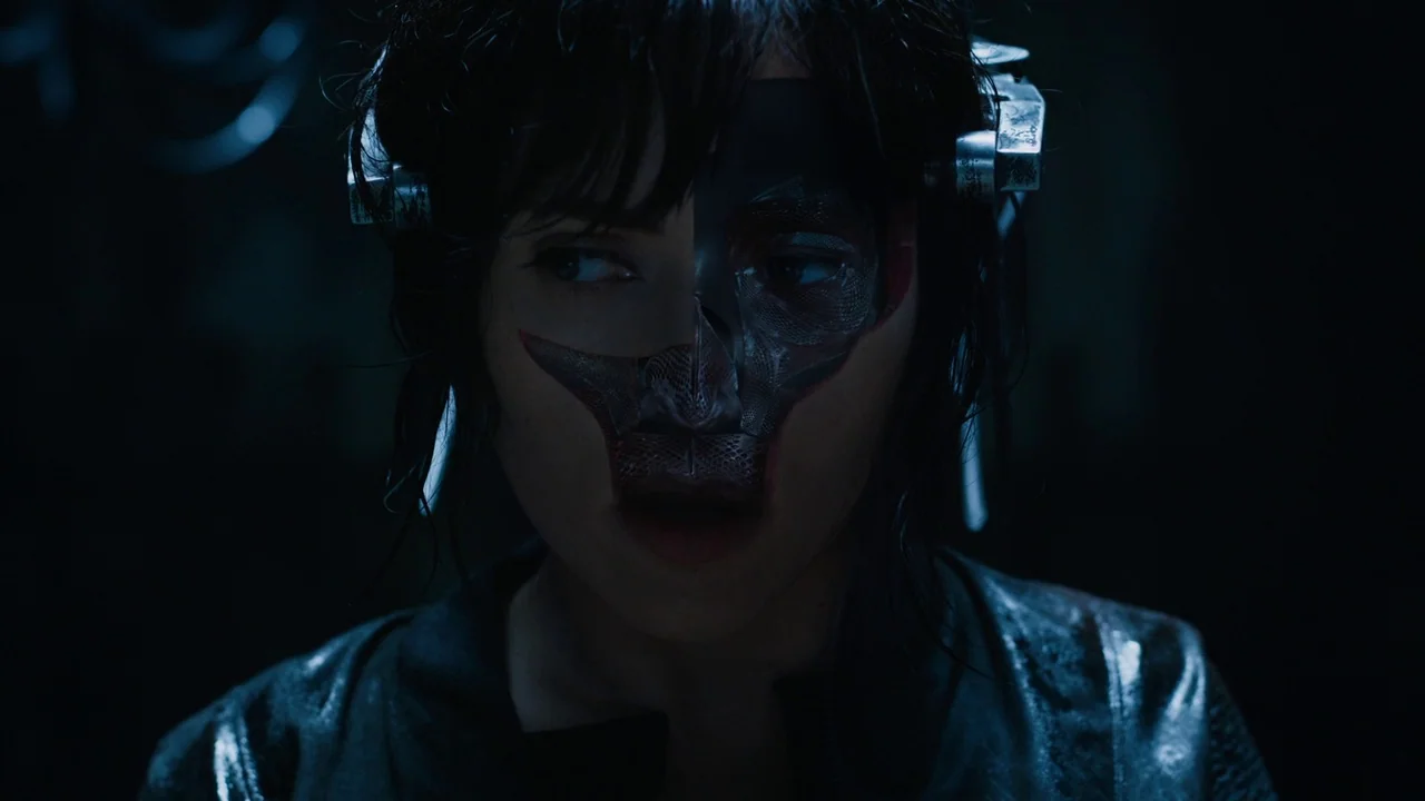 Ghost in the Shell (2017) movie still: closeup — A dark laboratory environment with minimal lighting creates deep shadows across the frame. A woman…