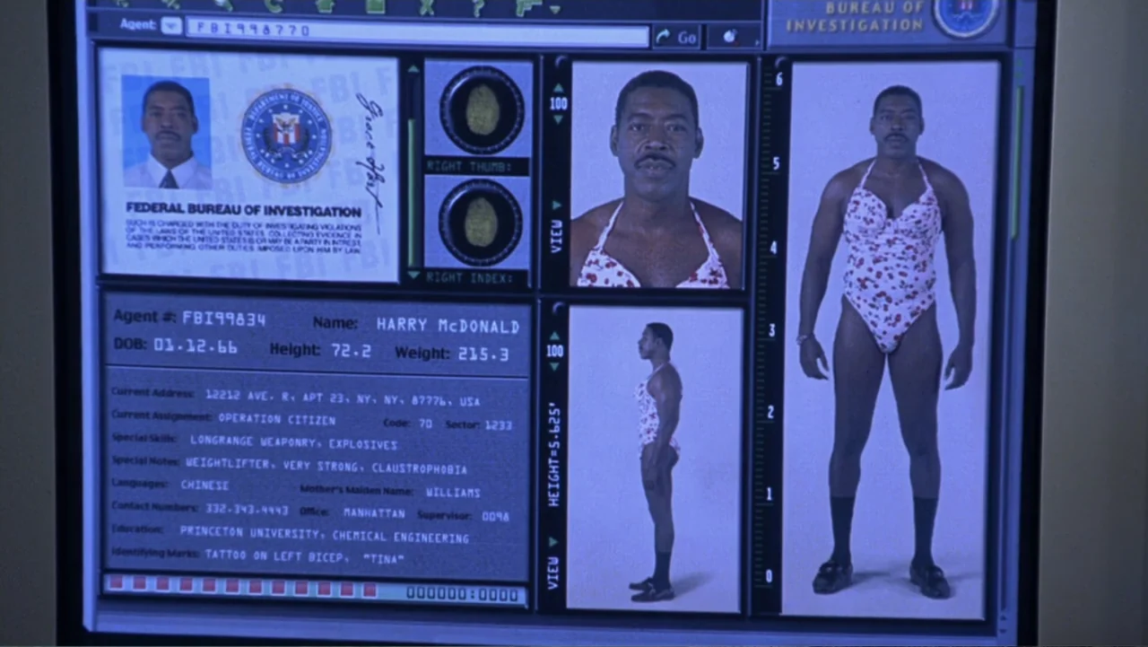Miss Congeniality (2000) movie still: medium — A computer interface displays a government identification file for a man named Harry McDonald. The…
