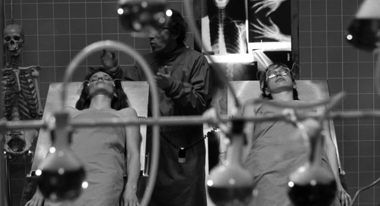 Stardust Memories (1980) movie still: medium — A clinical room features tiled walls decorated with various skeletal X-ray displays. A doctor stands…