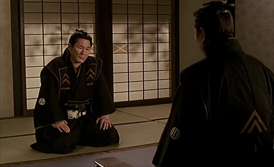 Gohatto (1999) movie still: medium — A traditional room with tatami mats and paper shoji screens as the wall divider. One man in a black kimono…
