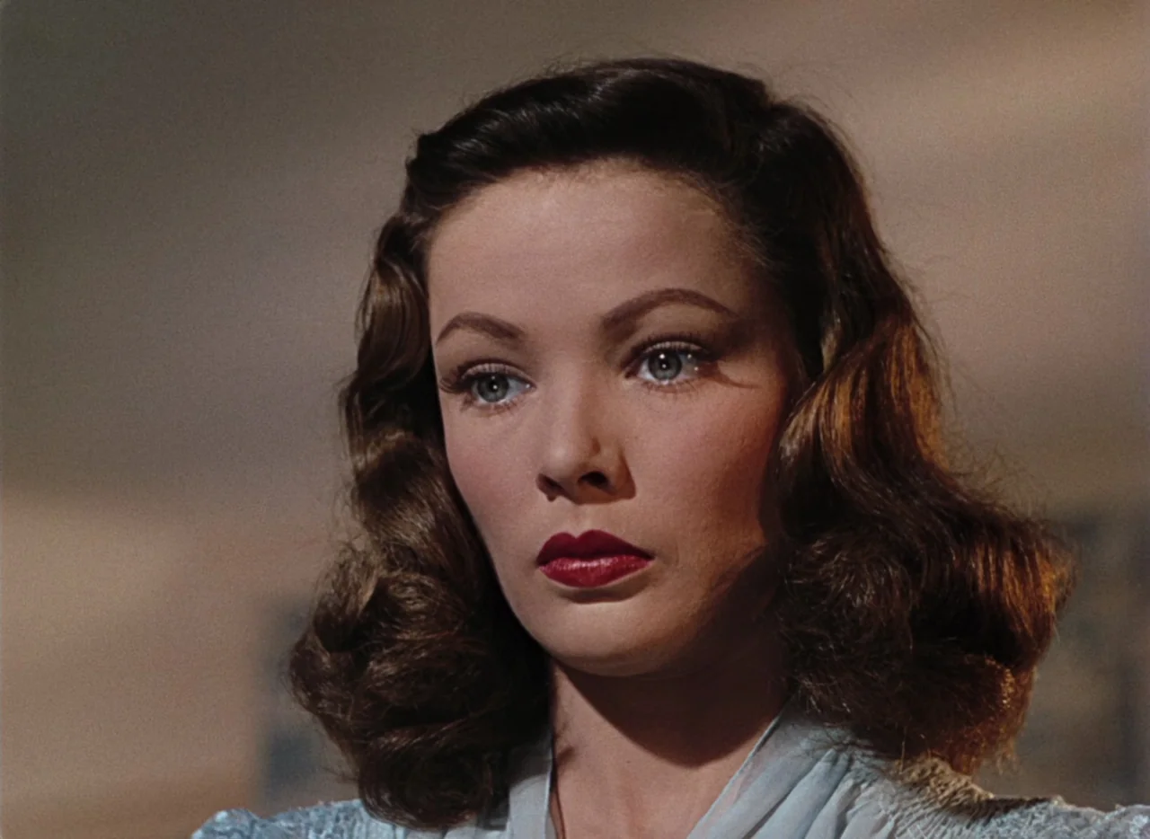 Leave Her To Heaven (1945) movie still: closeup — A woman stands in a softly lit room with neutral walls. She looks ahead with a steady, fixed…