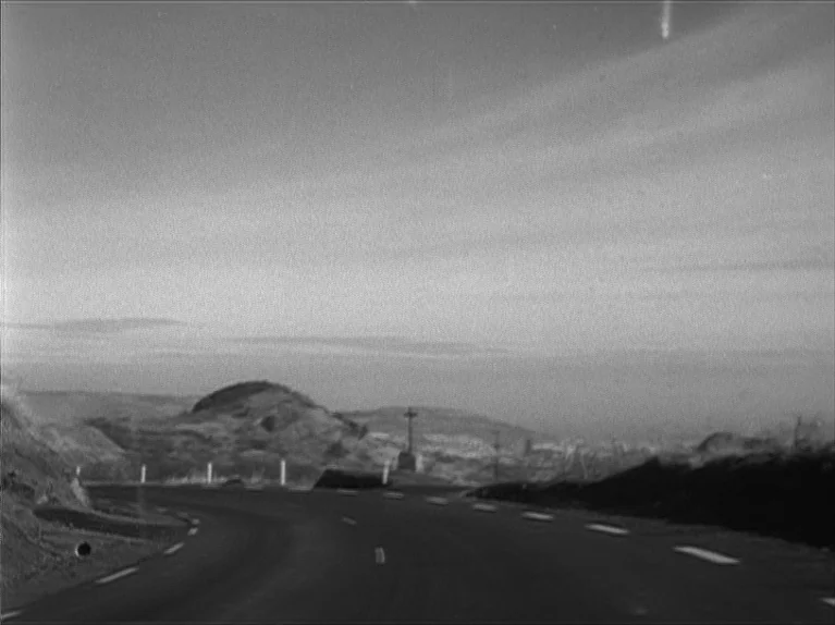My Night At Maud’s (Ma Nuit Chez Maud) (1969) movie still: establishing — A winding asphalt road passes through an undulating, sparse landscape…
