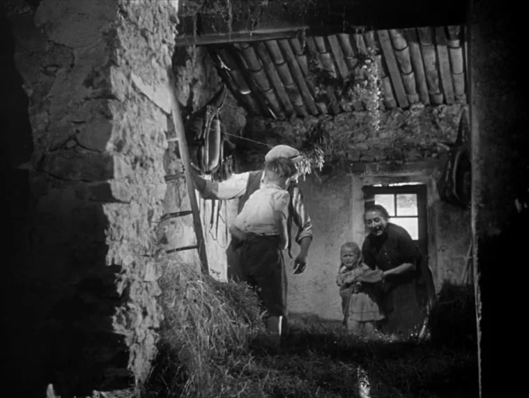 Forbidden Games (1952) movie still: medium — A rustic barn interior features stone walls, a wooden ladder, and piles of hay. An adult man and woman…