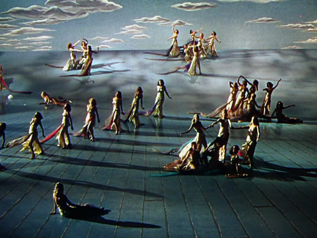 Ziegfeld Follies (1945) movie still: wide — A theatrical stage set displays a painted sky backdrop over a dark wooden floor. Many dancers in flowing…