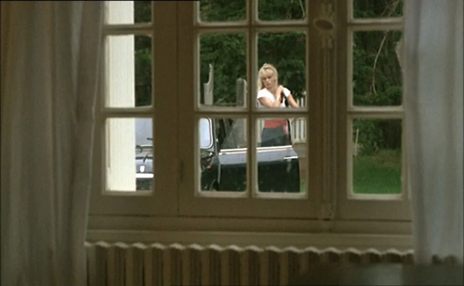 Pauline At the Beach (Pauline à la plage) (1983) movie still: medium — A view through a multi-pane window reveals a woman standing outside a house.…