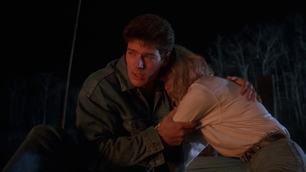 Friday the 13th Part VII: The New Blood (1988) movie still: medium — A wooden pier at night with dark trees in the distant background. A young man…