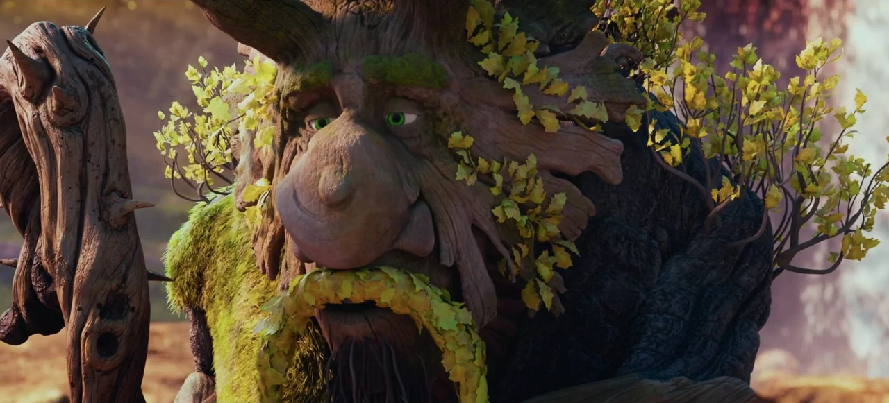 Mavka: The Forest Song (2023) movie still: closeup — An anthropomorphic tree creature stands in a brightly lit woodland environment with autumn…