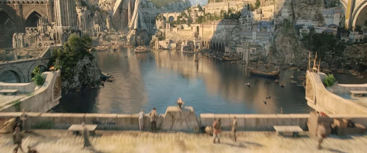 The Lord of the Rings: The Rings of Power (2022) movie still: wide — A sprawling fantasy port city features towering stone structures and a central…