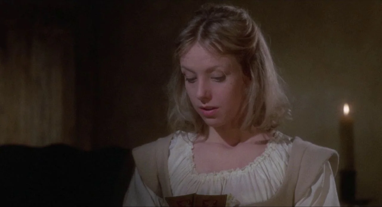 The Blood on Satan’s Claw (1971) movie still: closeup — A dimly lit room with plain walls features a lit candle in the background. A young woman…