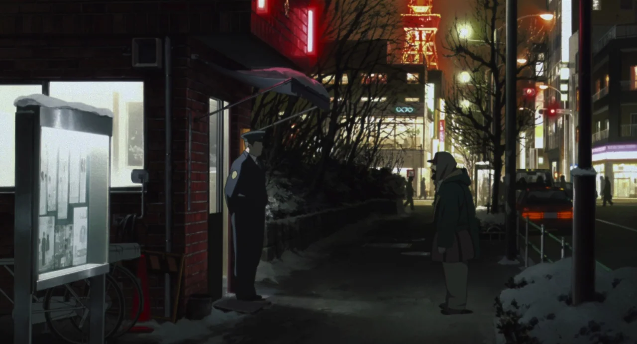 Tokyo Godfathers (2003) movie still: wide — A snowy urban sidewalk at night features a small brick police box building. A uniformed officer stands…