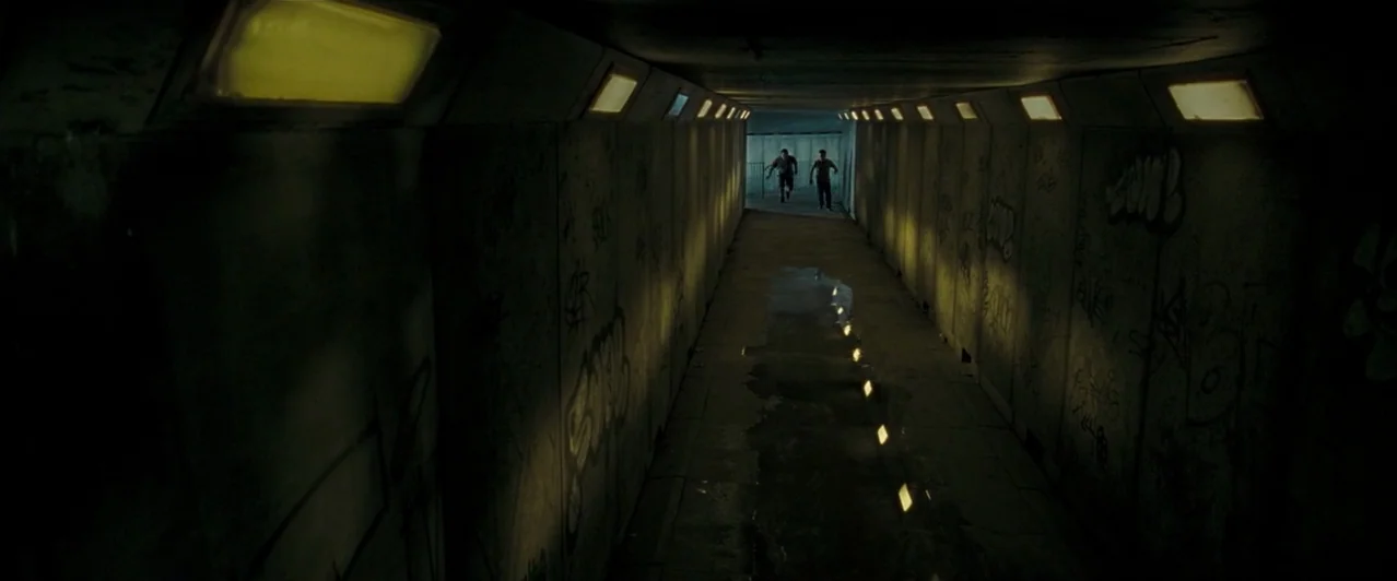 Harry Potter & The Order of the Phoenix (2007) movie still: wide — A long concrete pedestrian underpass features walls covered in dark spray-painted…