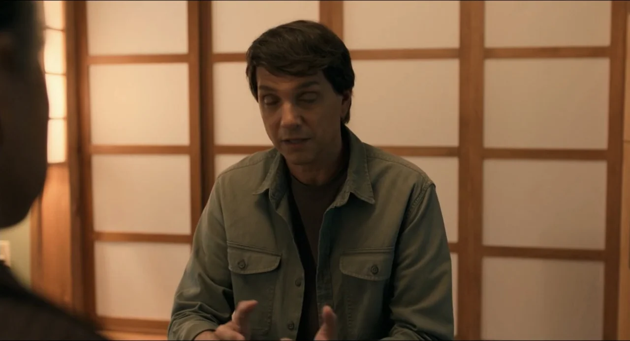 Karate Kid: Legends (2025) movie still: medium — An interior space features a shoji-style screen partition with a wooden grid pattern. A man in an…