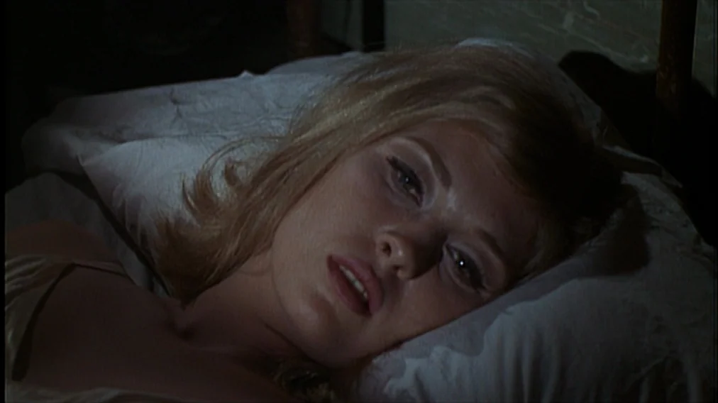 Bonnie And Clyde (1967) movie still: closeup — A dimly lit room contains a white pillow on a bed. A blonde woman rests her head on the pillow.