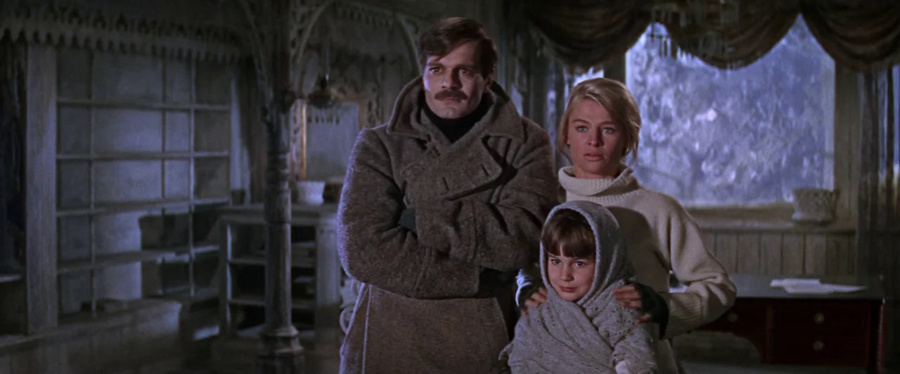Doctor Zhivago (1965) movie still: medium — A rustic wooden interior features an ornate arched entryway and a large covered window. Three people…