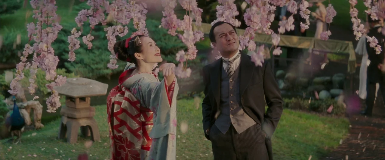 Memoirs of a Geisha (2005) movie still: medium — A Japanese park is filled with blooming cherry trees under a bright sky. A woman in a traditional…