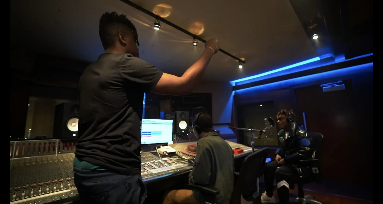 Juice WRLD: Into the Abyss (2021) movie still: medium — A dimly lit professional recording studio features a large mixing console and computer…