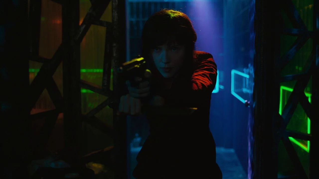 Ghost in the Shell (2017) movie still: medium — An interior space features geometric dark structural frames illuminated by neon light strips. A…