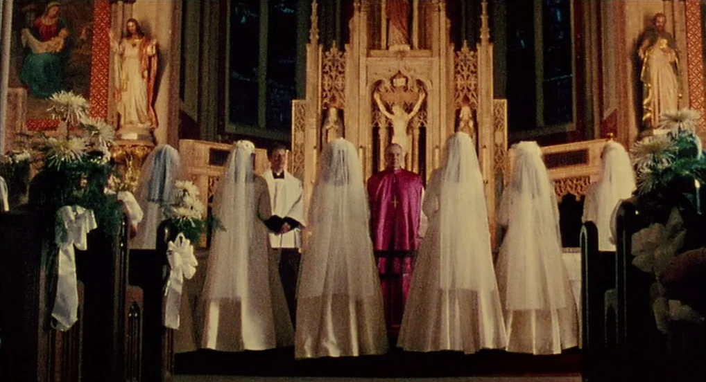 Dead Man Walking (1995) movie still: wide — The interior of a church with a central altar featuring religious statues. Four brides in white gowns…