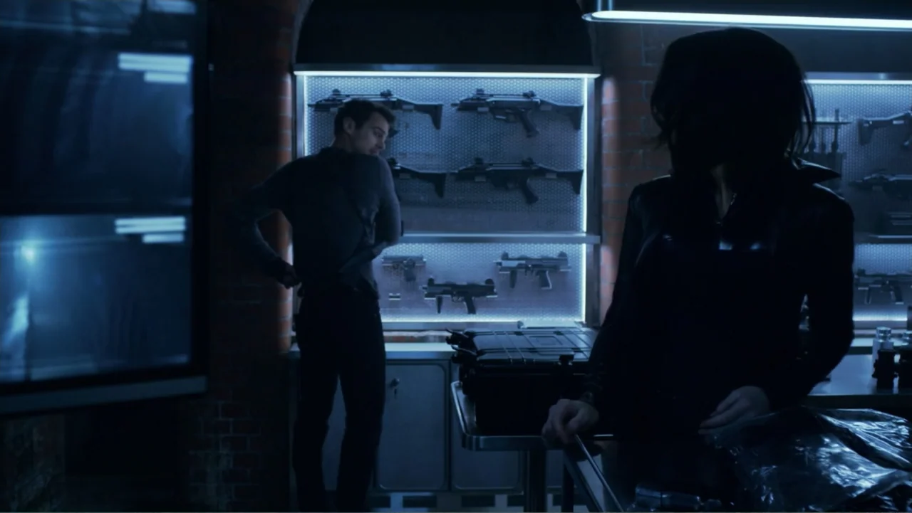 Underworld: Blood Wars (2016) movie still: medium — An industrial armory with brick walls features rows of mounted firearms behind illuminated…
