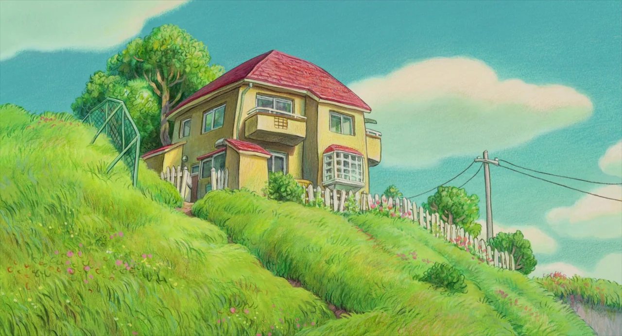 Ponyo (2008) movie still: establishing — A yellow two-story house sits atop a vibrant green grassy hill under a bright sky. A white picket fence…