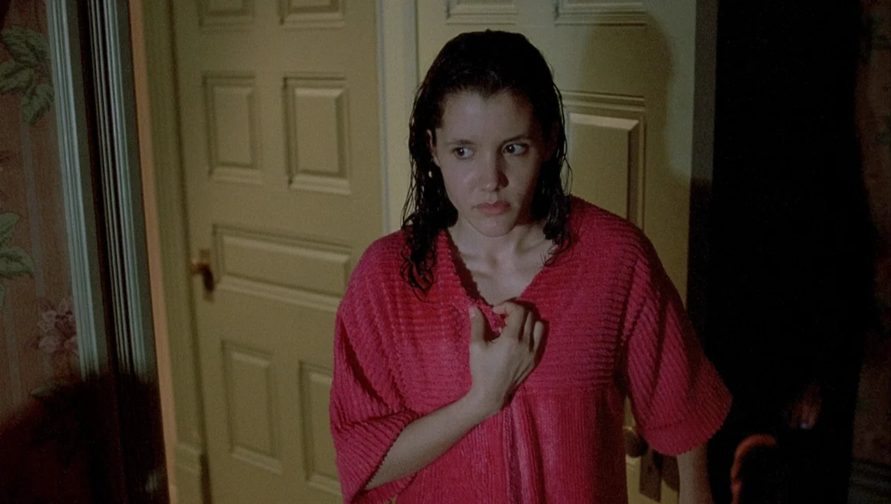 Necronomicon: Book of Dead (1993) movie still: medium — A domestic interior with beige painted doors and floral wallpaper in a narrow hallway. A…
