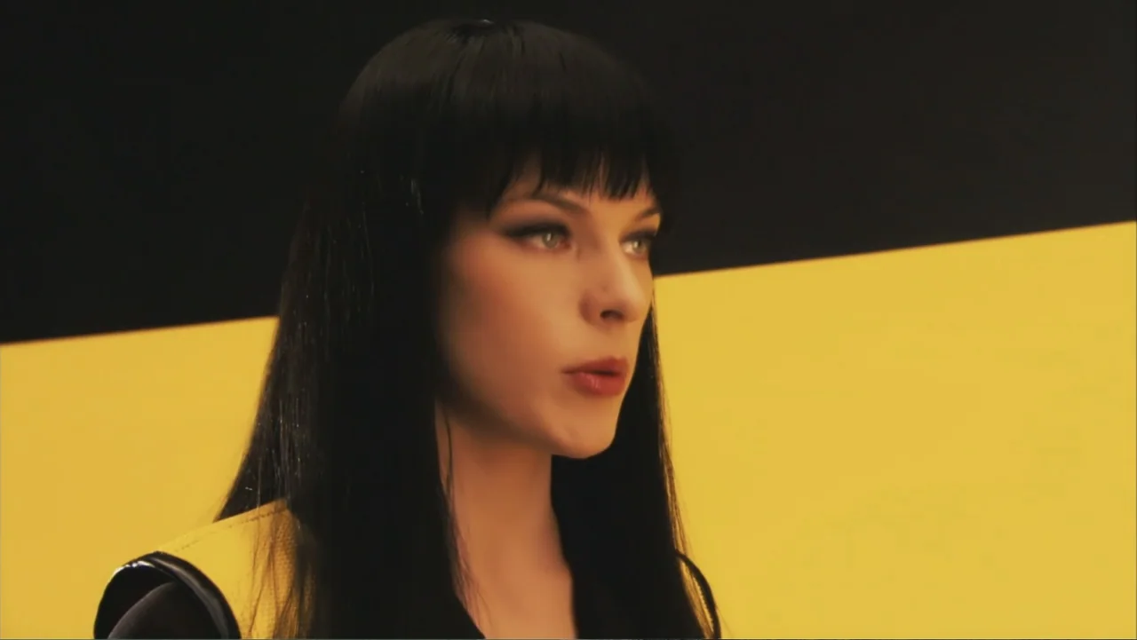 Ultraviolet (2006) movie still: closeup — A minimalist studio space features a sharp diagonal divide between black and yellow sections. A young…