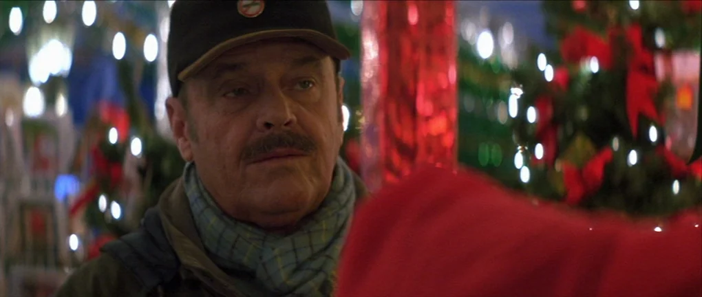 The Pledge (2001) movie still: closeup — A dimly lit retail environment features out-of-focus holiday decorations in the background. An older man…
