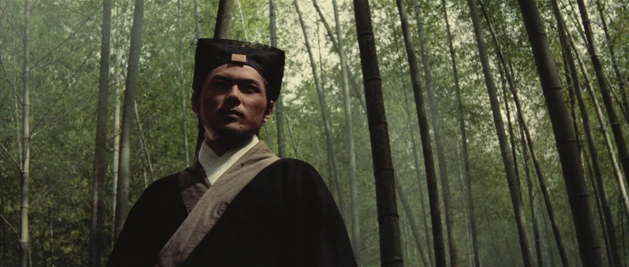 A Touch of Zen (1971) movie still: medium — A dense bamboo forest with tall, slender vertical stalks filling the frame. A man in traditional…