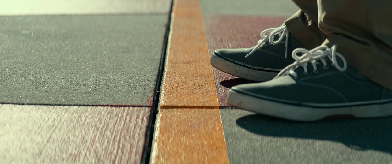 Halloween (2018) (2018) movie still: closeup — A textured outdoor surface features painted rectangular zones separated by a bright orange line. A…