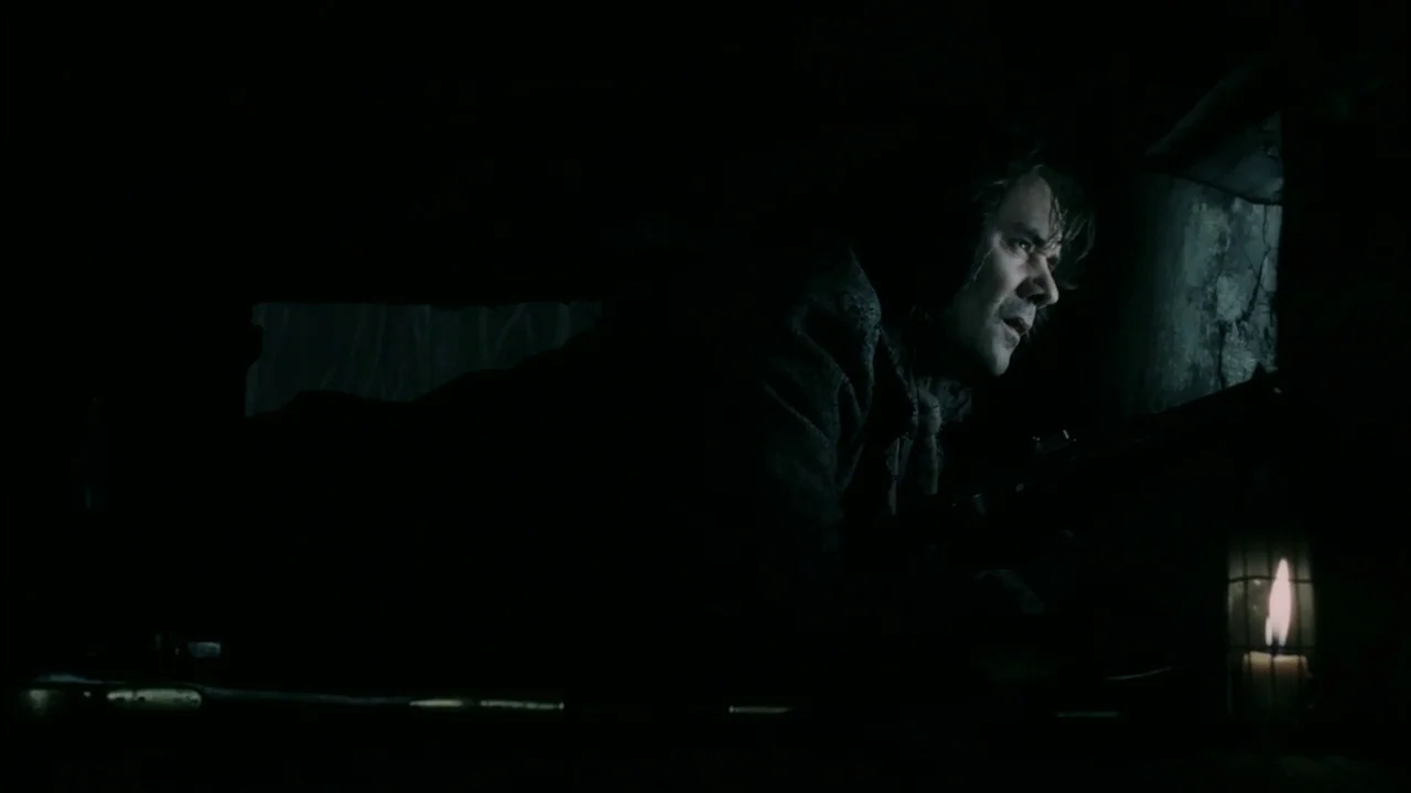 Sleepy Hollow (1999) movie still: medium — A dark, cramped dugout environment features rough wooden beams and shadows. A man lies flat on the dirt…