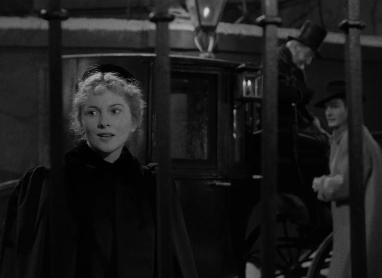Letter From An Unknown Woman (1948) movie still: medium — A night exterior setting with iron railings in the foreground and a horse-drawn carriage.…